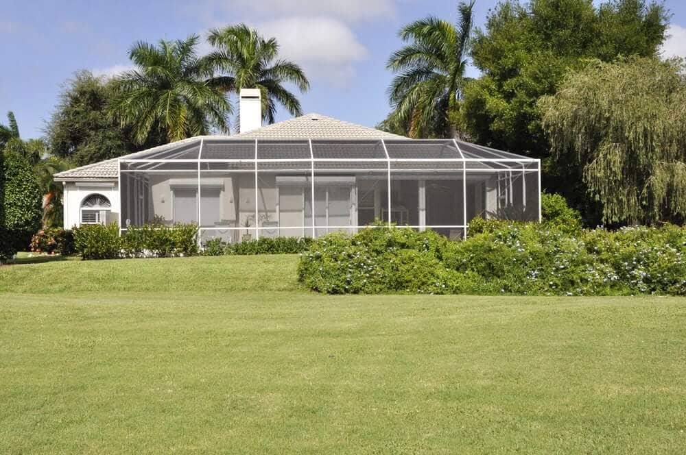 Rescreened pool enclosure on a Jupiter FL home surrounded by palms
